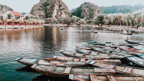 Sailboats moored in lake against mountain