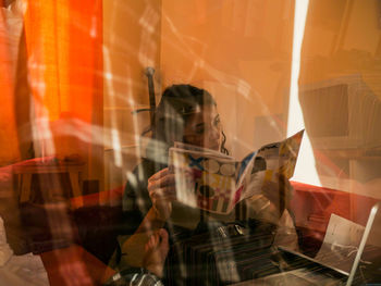 Reflection of boy sitting in mirror