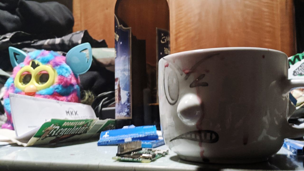 CLOSE-UP OF COFFEE CUP ON TABLE WITH TOY