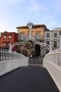 Bridge amidst buildings in city against sky