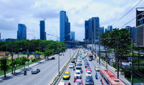 Traffic on road amidst buildings in city against sky