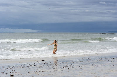 Full length of person on beach against sky