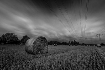 Hay bales on field against sky