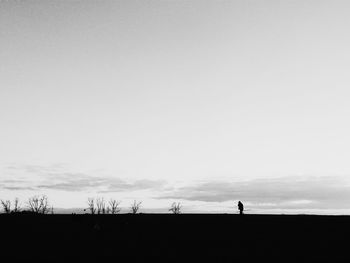 Silhouette men standing on landscape against sky