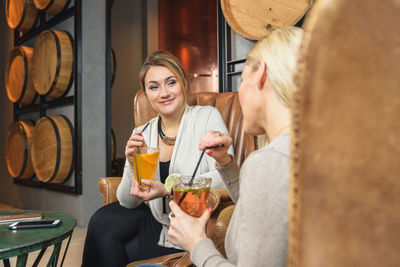 Happy women drinking cocktails and talking