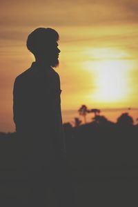 Silhouette woman standing against sky during sunset