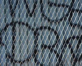 Graffiti on chainlink fence and metal wall