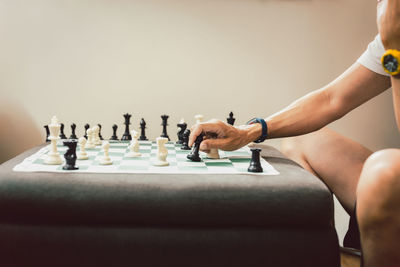 Man playing chess board game at home.