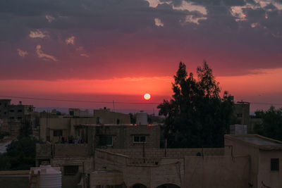 High angle view of townscape by sea against orange sky