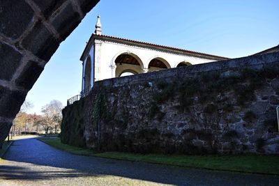 Low angle view of arch bridge and building against clear sky