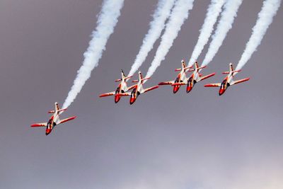 Low angle view of fighter planes flying against sky