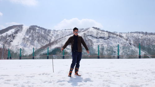 Full length of man standing on snow against mountain