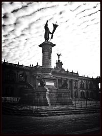 Low angle view of statue against cloudy sky