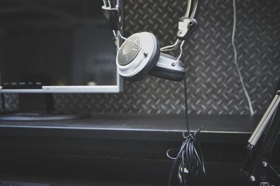 Close-up of headphones and television at recording studio