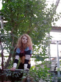 Portrait of smiling young woman against trees