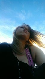 Low angle view of woman standing against sky