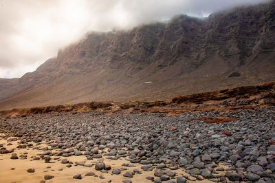 Scenic view of land and mountains against sky