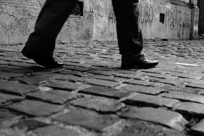 Low section of people standing on cobblestone