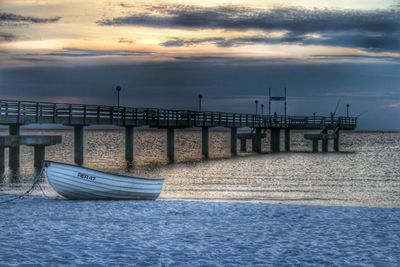 Pier on sea at sunset