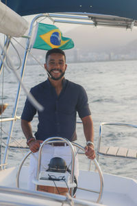 Portrait of smiling young man sailing on sea