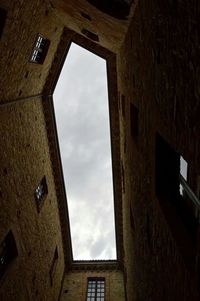 Low angle view of building against cloudy sky