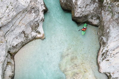 High angle view of man kayaking amidst rock formations