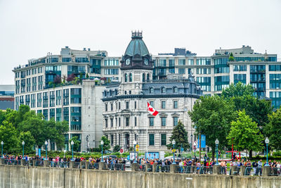 People in front of buildings against clear sky