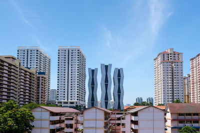 Skyscrapers in city against blue sky