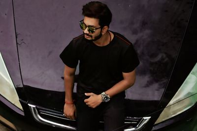 Young man standing by car