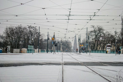 Railroad tracks on snow covered street against sky