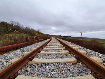 Surface level of railroad tracks against sky