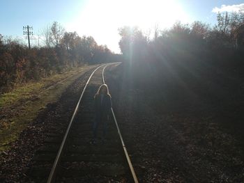 Railway tracks amidst trees against sky