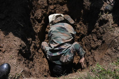 Rear view of man sitting on rock