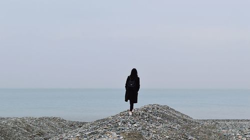 Rear view of woman looking at sea against sky