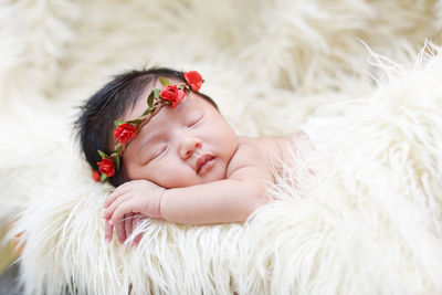 Close-up of cute baby girl sleeping on rug at home