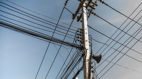 Low angle view of electricity pylon against clear sky