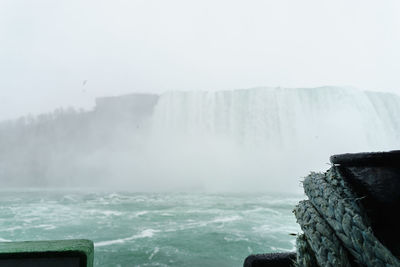 Scenic view of waterfall against sky during winter