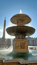 Fountain in front of building against clear sky