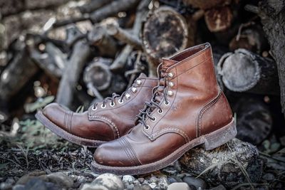 Close-up of leather shoes against logs