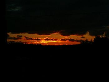 Silhouette of landscape against cloudy sky