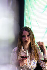 Beautiful young woman drinking glass