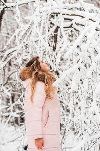 Woman standing on snow covered tree