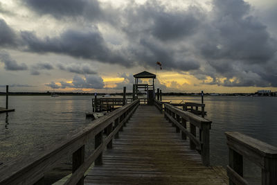 Pier over sea against sky during sunset