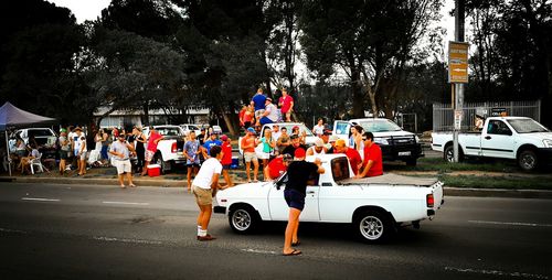 Rear view of people standing on road