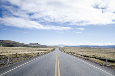 Empty road along countryside landscape