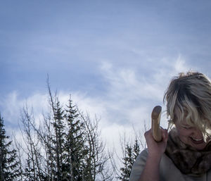 Woman with arms raised against sky