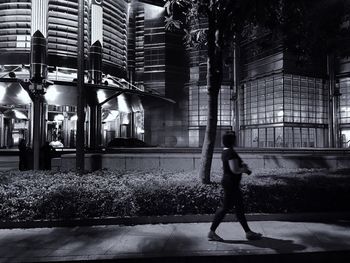 Full length of woman walking on illuminated city at night