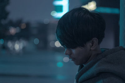 Close-up portrait of boy looking away at night