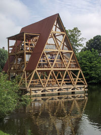 Built structure by lake against sky