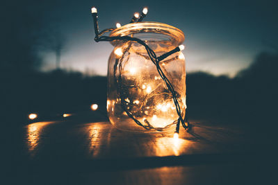 Close-up of illuminated string lights in jar at night